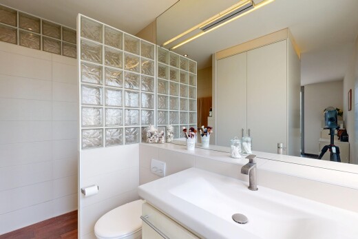 salle de bains avec toilette, lavabo (ou coiffeuse selon le contexte), évier, inside property, et mur en carrelage