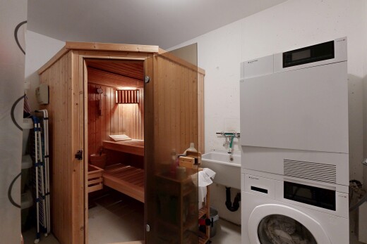 buanderie avec sauna, inside property, évier, lave-linge et sèche-linge superposés, et light floor