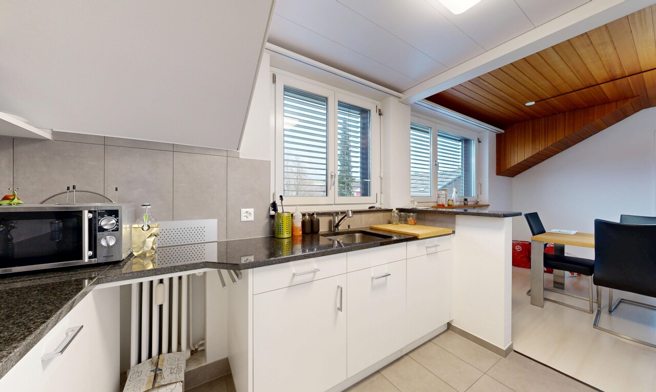 kitchen featuring backsplash, white cabinetry, stainless steel microwave, and light tile patterned floors