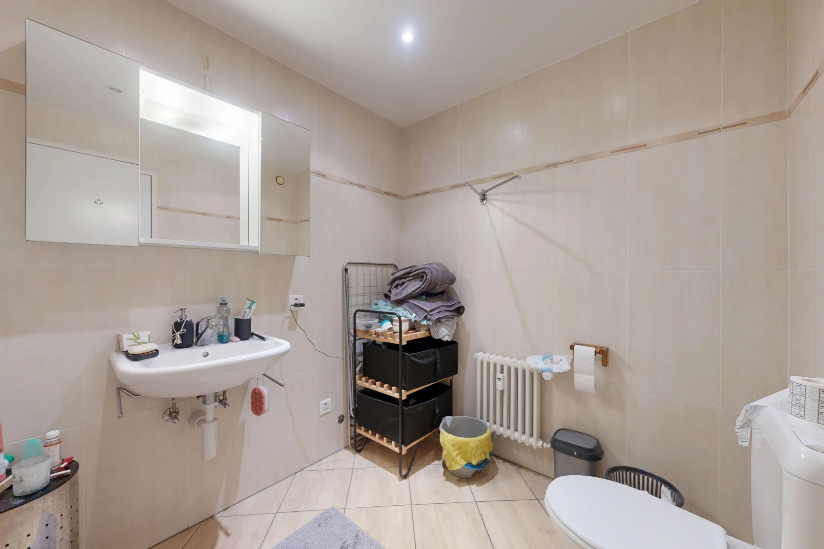 bathroom with radiator, light tile patterned floors, and recessed lighting