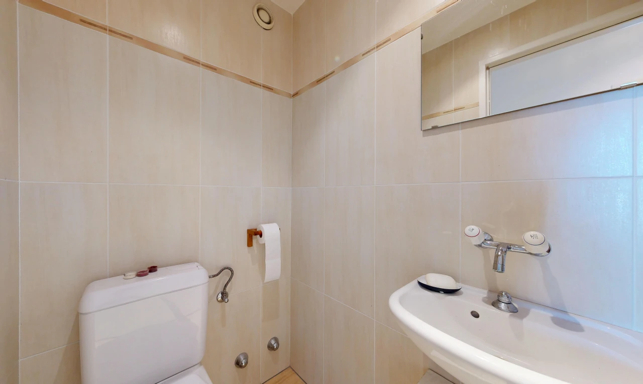 half bathroom featuring a sink and tile walls