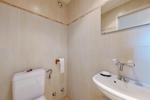 salle de bains avec évier, toilette, mur en carrelage, tile wall, et miroir