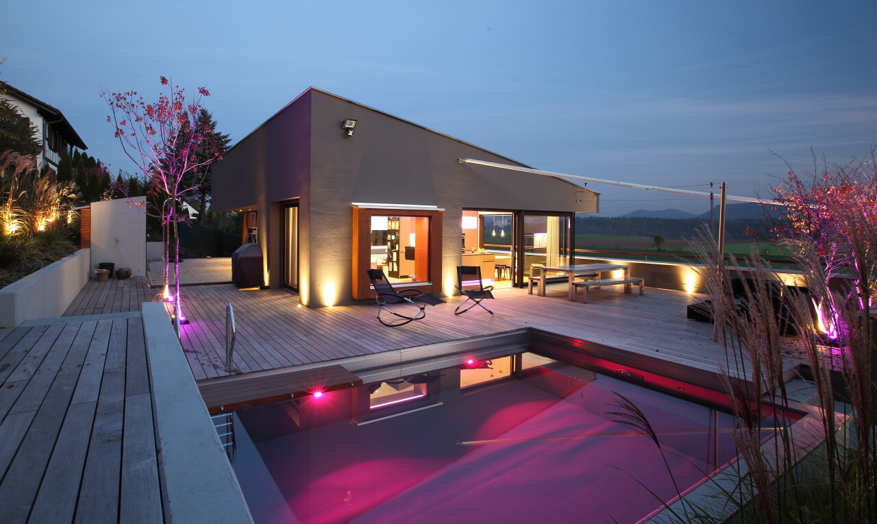 außenansicht mit deck, from property, schwimmbad, stuckverkleidung, und dusk
