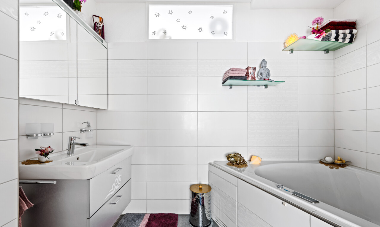 full bathroom with a garden tub, vanity, tile walls, and dark tile patterned flooring