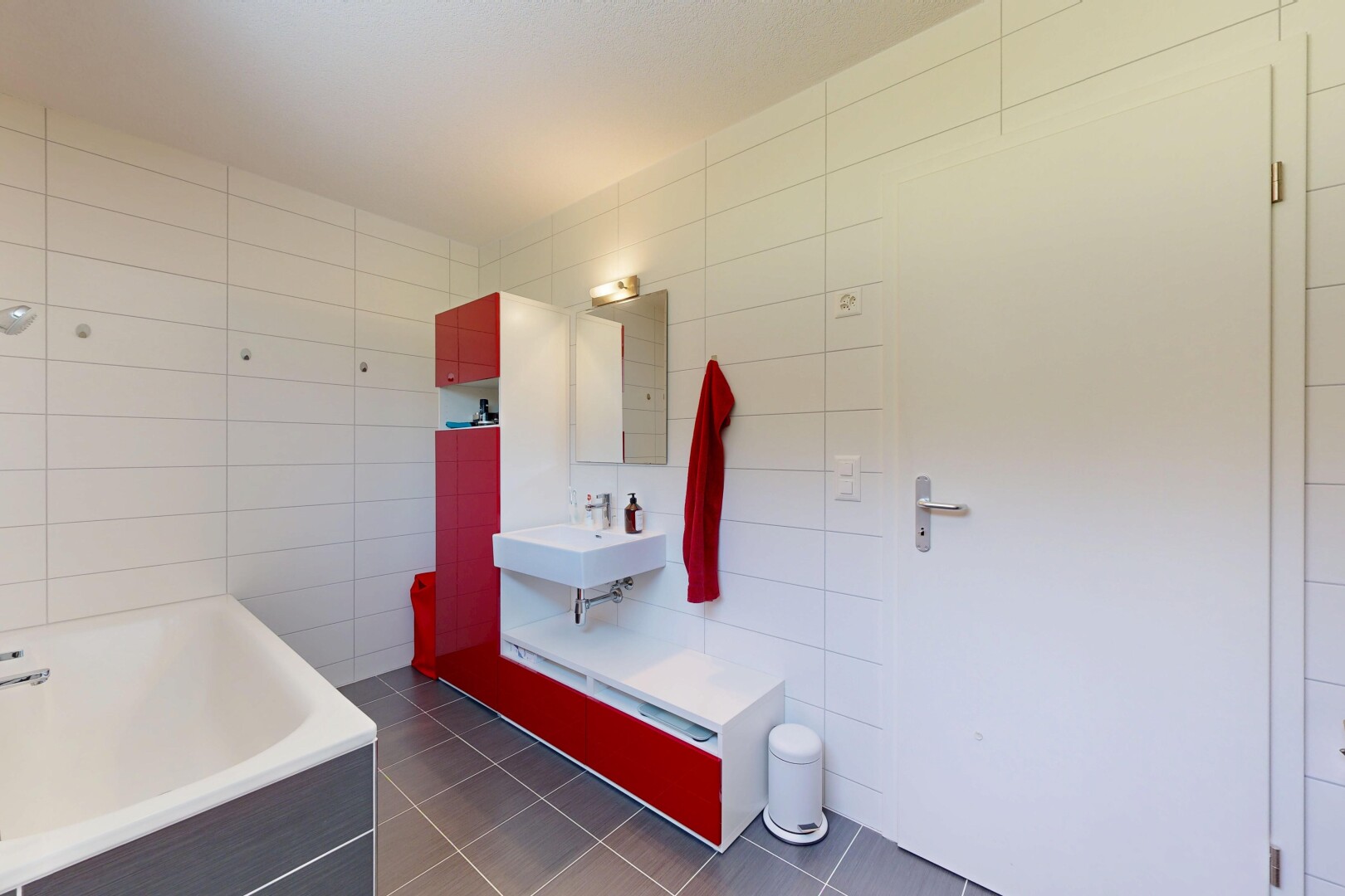 bathroom featuring a bath, tile walls, and dark tile patterned flooring