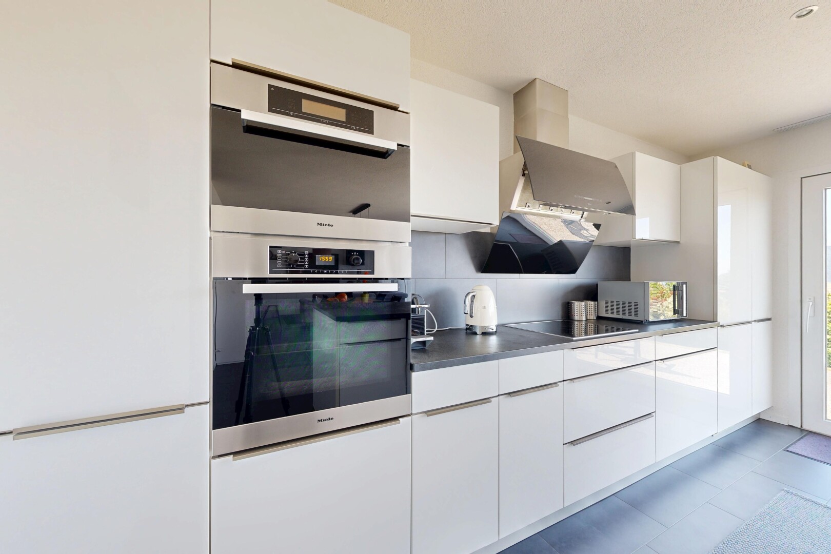 kitchen featuring white cabinets, modern cabinets, dark countertops, and stainless steel double oven