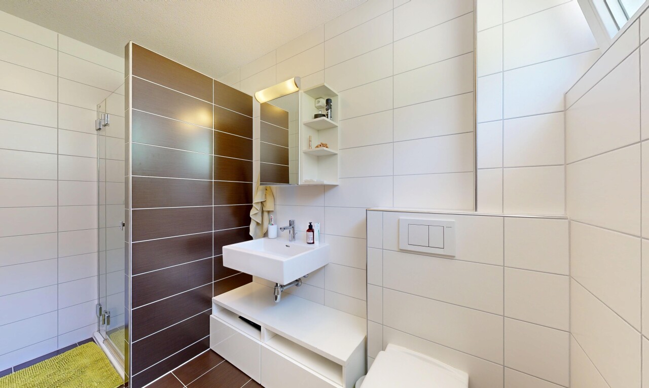 bathroom featuring tile walls and a shower stall