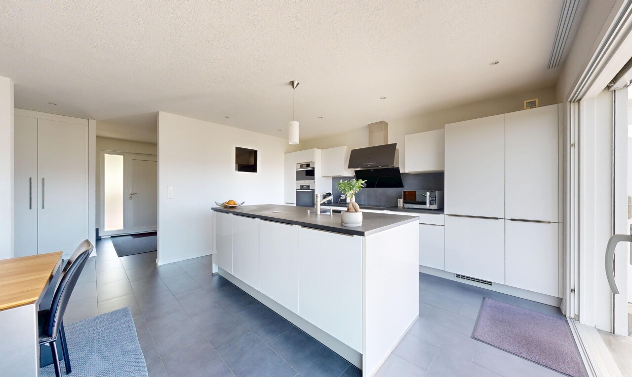 kitchen featuring a center island with sink, white cabinets, dark countertops, stainless steel appliances, and decorative light fixtures
