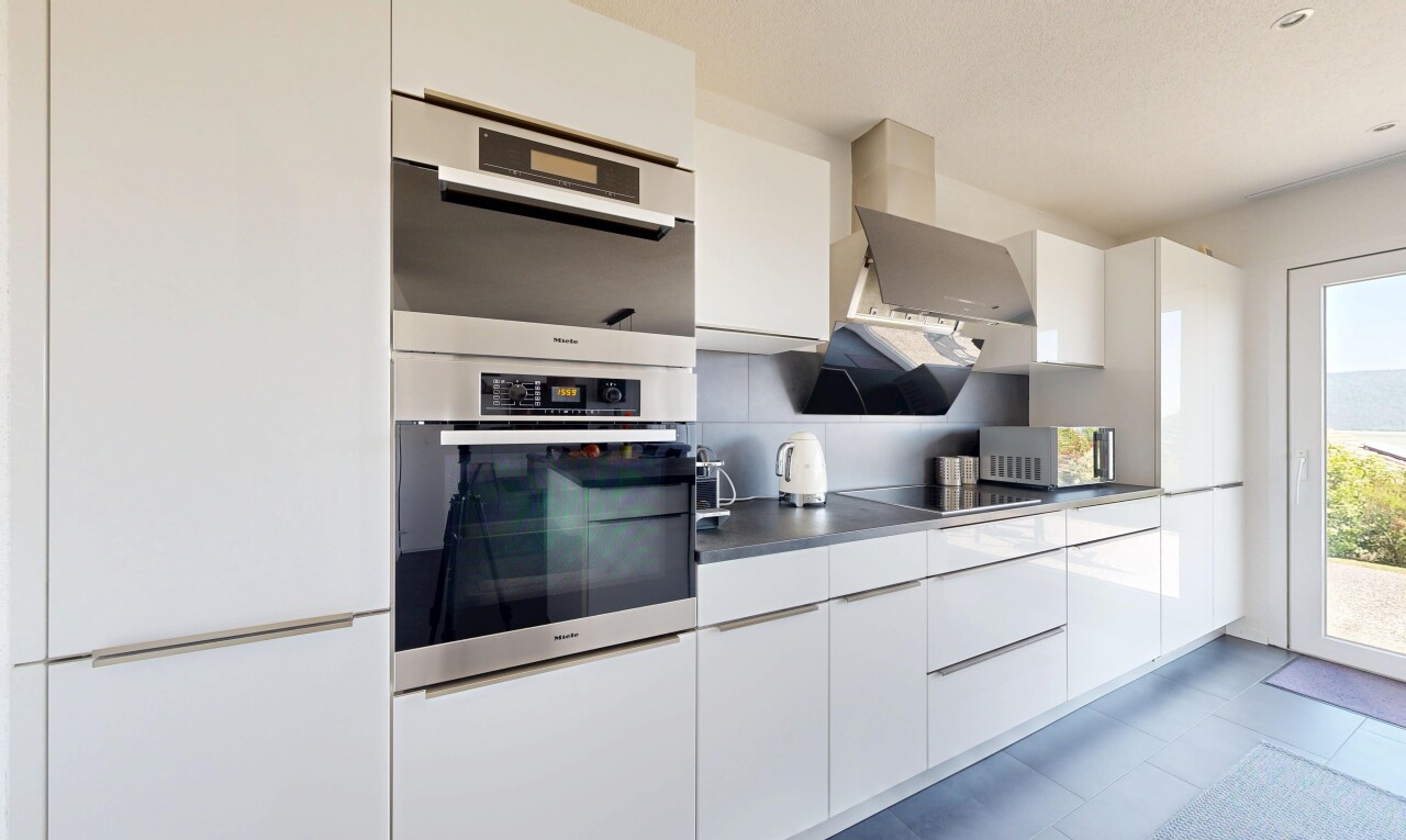 kitchen featuring white cabinets, modern cabinets, dark countertops, and stainless steel double oven