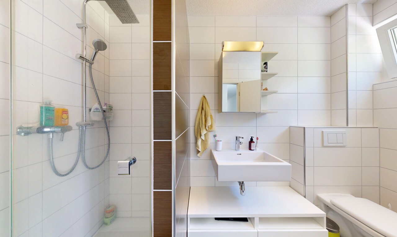 full bathroom featuring a tile shower, tile walls, and vanity