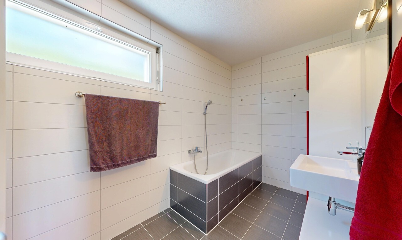 full bath with tile walls and dark tile patterned flooring