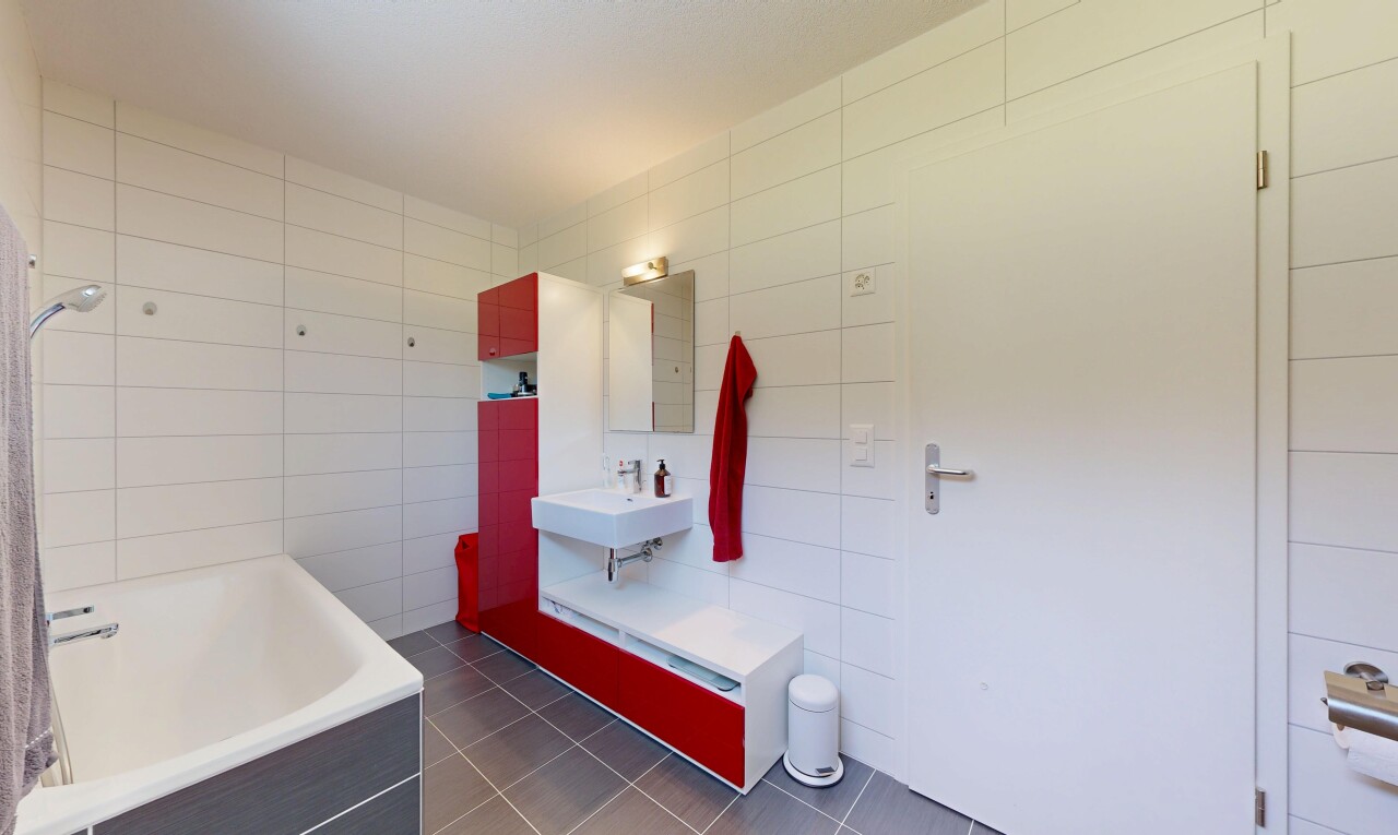 bathroom featuring a bath, tile walls, and dark tile patterned flooring