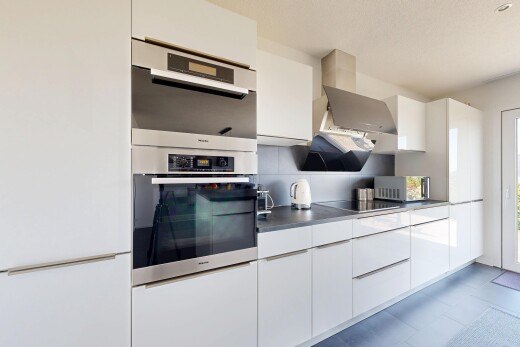kitchen featuring white cabinets, modern cabinets, dark countertops, and stainless steel double oven