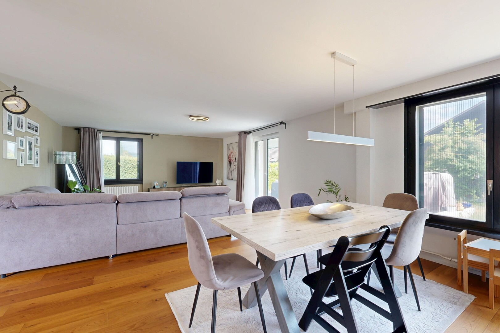 wohn- / esszimmer mit holzfußboden, wood finish floor, gipskartonwand, drywall, und fernseher