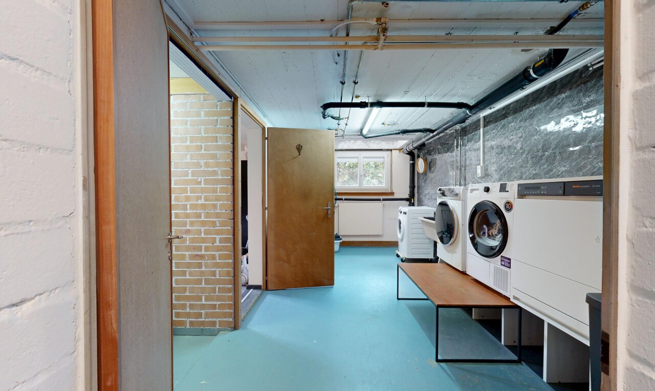 wäschekammer mit natürliches licht, tumbler, finished concrete floor, concrete floor, und keller