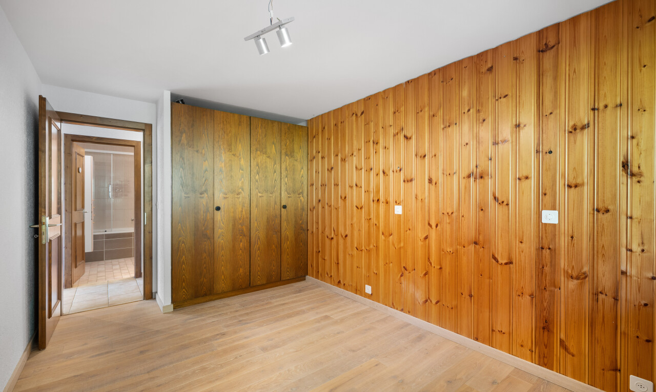 chambre avec wood finish floor, sol en finition bois, inside property, placard, et track lighting