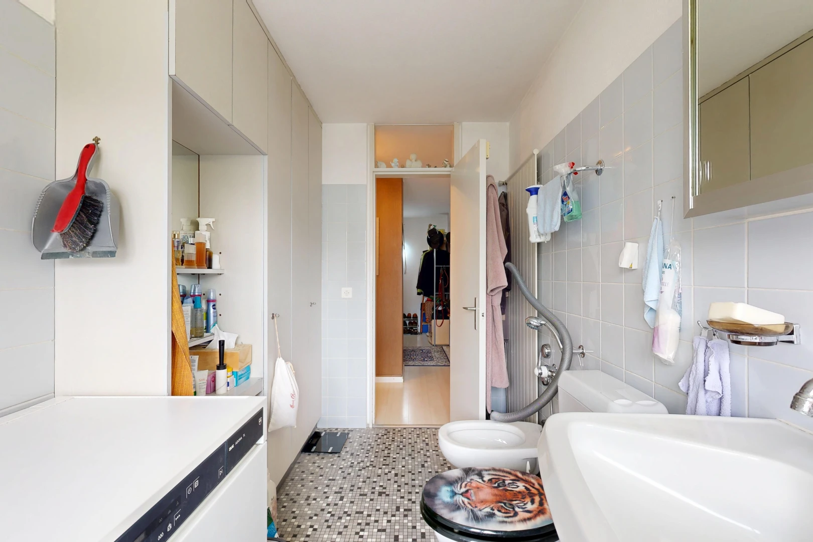 salle de bains avec évier, tile wall, mur en carrelage, light floor, et miroir