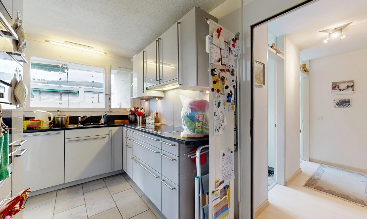 cuisine avec dark countertops, plans de travail, light floor, tile floor, et sol en carrelage