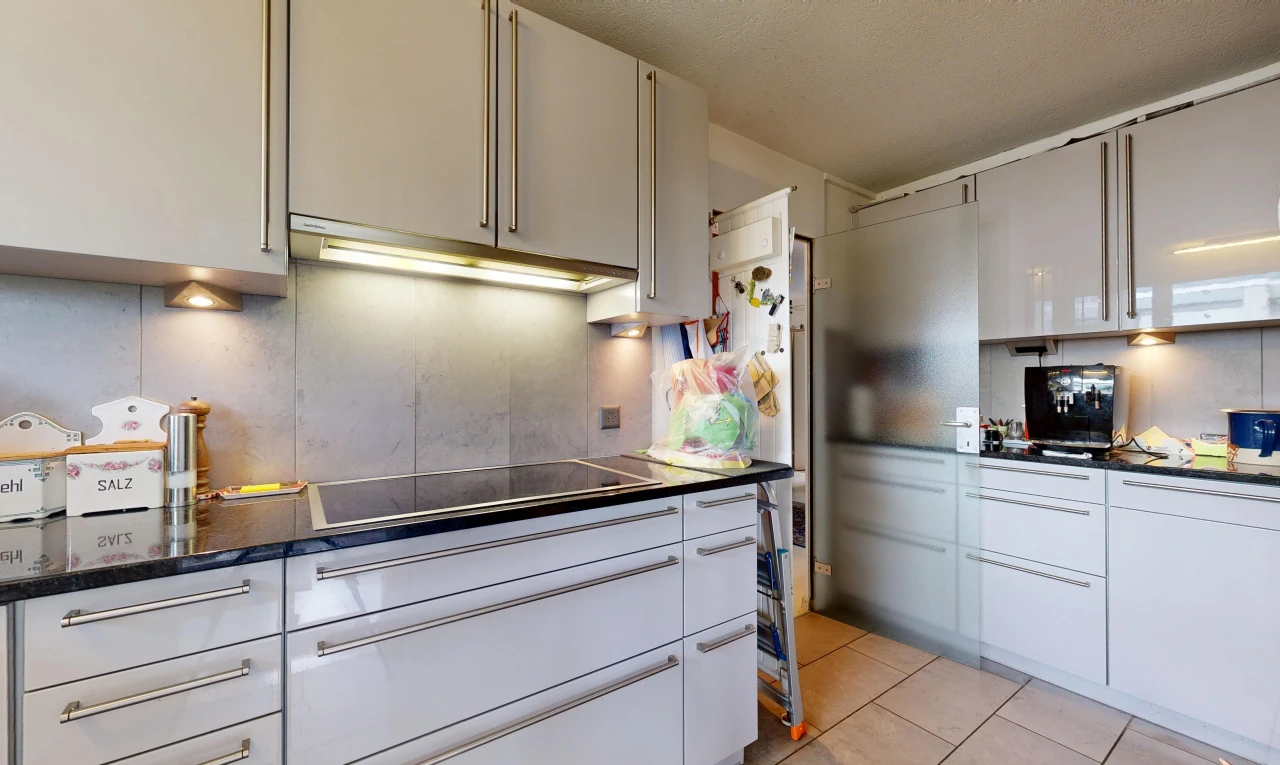 cuisine avec dark countertops, plans de travail, hotte, light floor, et tile floor