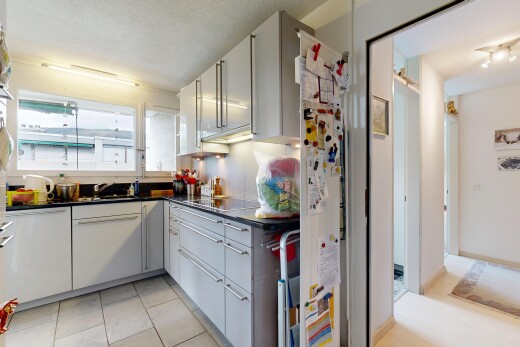 cuisine avec dark countertops, plans de travail, light floor, tile floor, et sol en carrelage