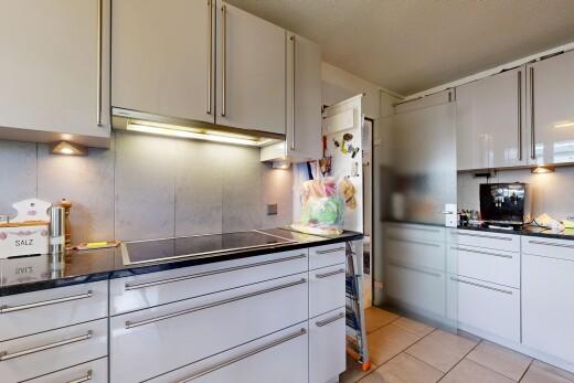 cuisine avec dark countertops, plans de travail, hotte, light floor, et tile floor