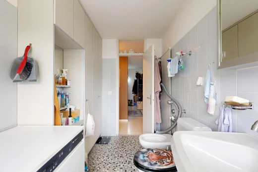 salle de bains avec évier, tile wall, mur en carrelage, light floor, et miroir