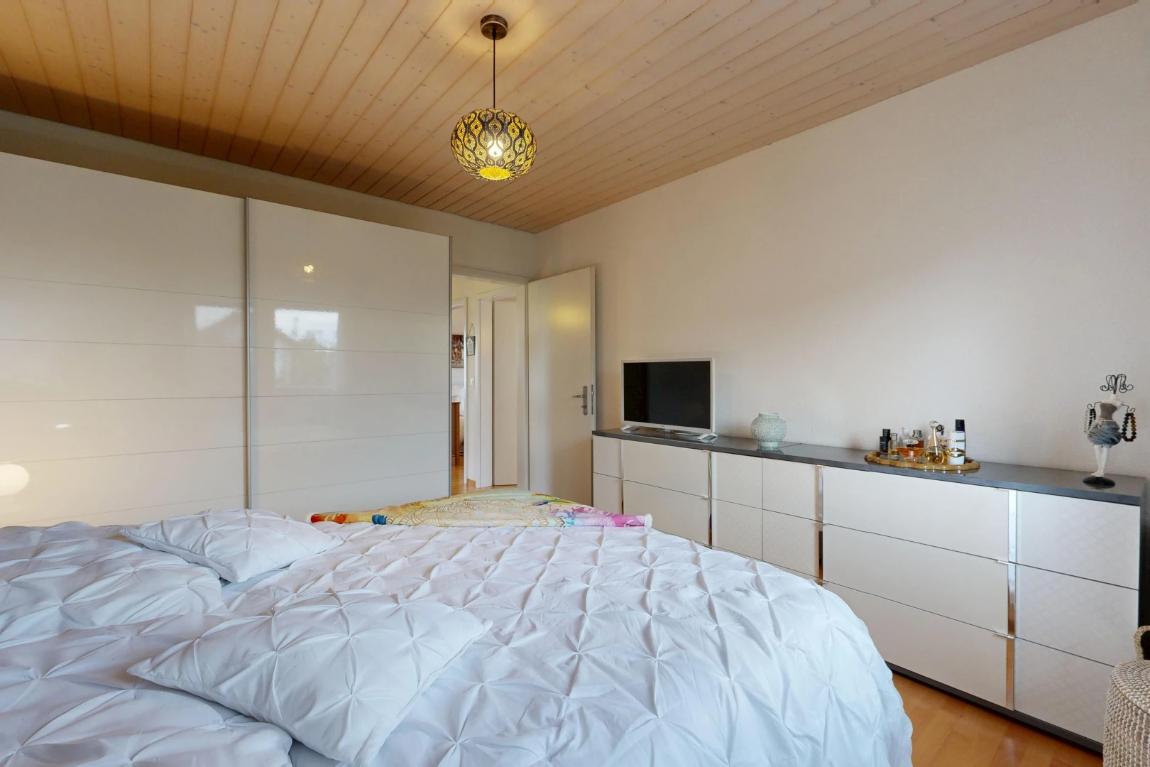 chambre avec éclairage suspendu, wood ceiling, plafond en bois, télévision, et drywall