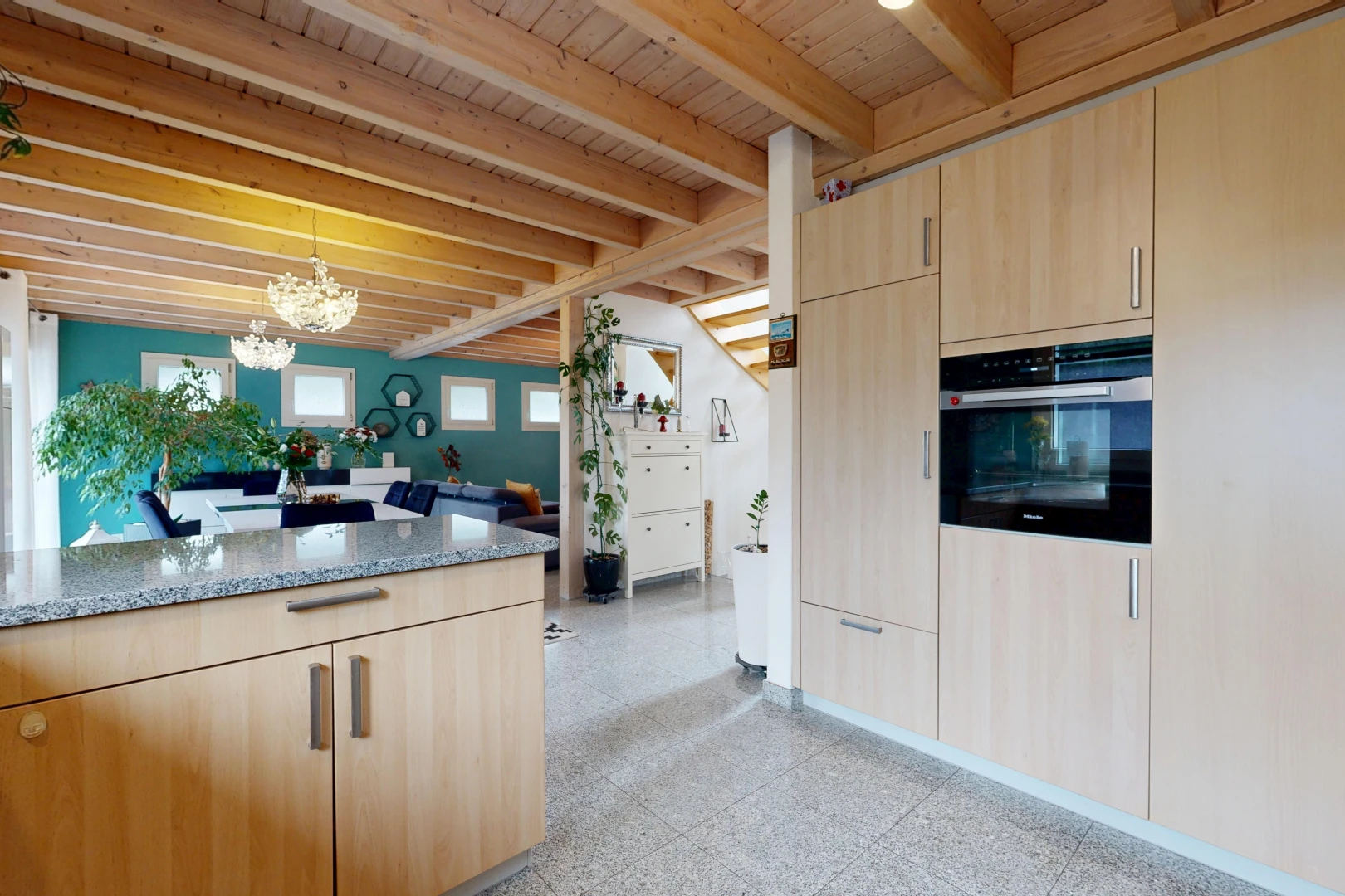 cuisine avec light brown cabinets, armoires marron clair, stone countertops, plans de travail en pierre, et beamed ceiling