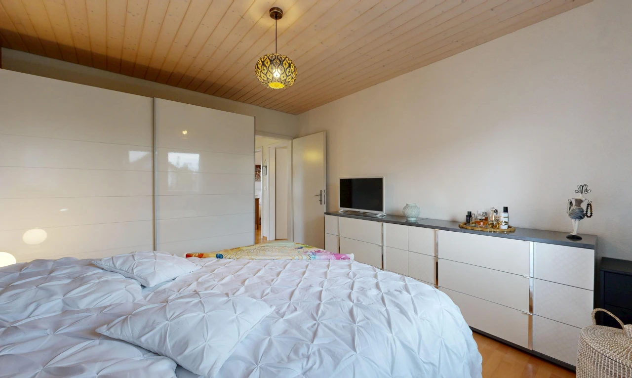 chambre avec éclairage suspendu, wood ceiling, plafond en bois, télévision, et drywall