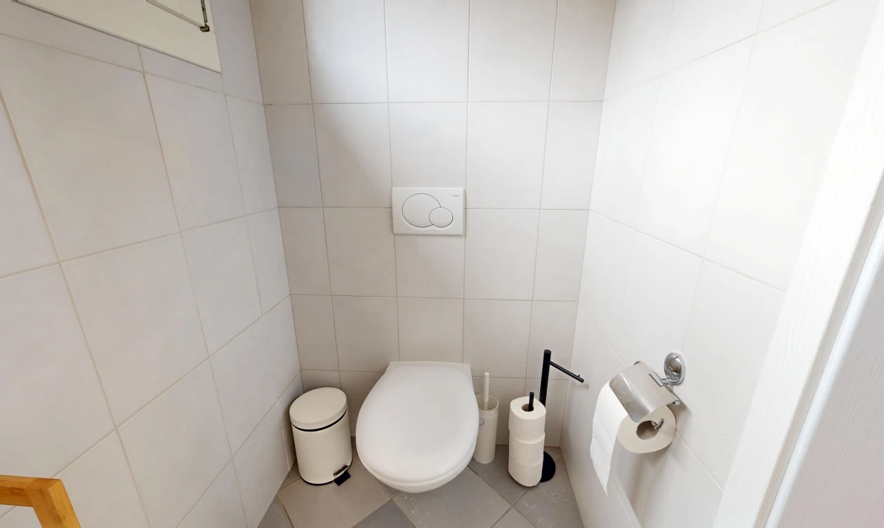 salle de bains avec tile floor, sol en carrelage, tile wall, mur en carrelage, et toilette