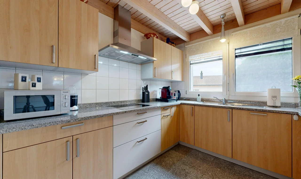 cuisine avec hotte, light brown cabinets, armoires marron clair, micro-ondes, et backsplash