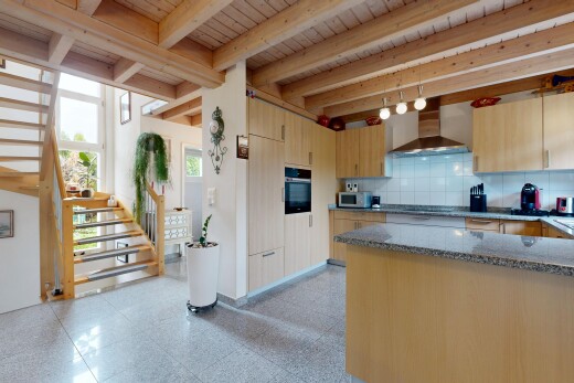 cuisine avec escaliers, hotte, stone countertops, plans de travail en pierre, et beamed ceiling