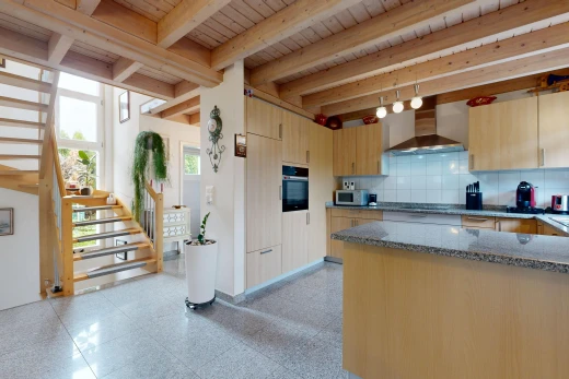 cuisine avec escaliers, hotte, stone countertops, plans de travail en pierre, et beamed ceiling
