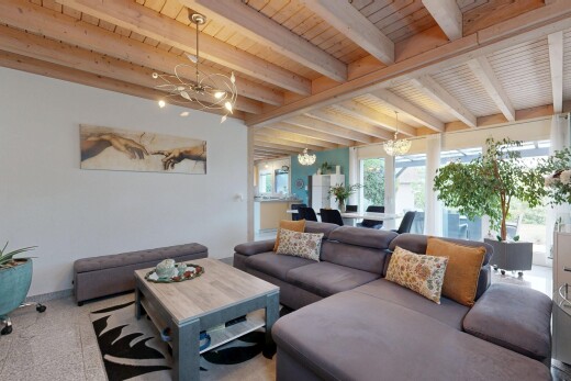 salon avec beamed ceiling, plafond à poutres, drywall, cloison sèche, et high end ceiling