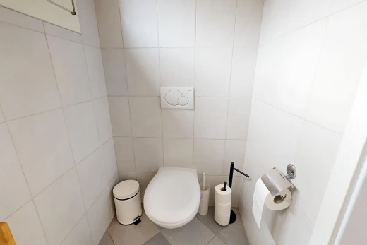 salle de bains avec tile floor, sol en carrelage, tile wall, mur en carrelage, et toilette