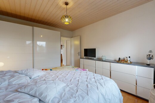 chambre avec éclairage suspendu, wood ceiling, plafond en bois, télévision, et drywall