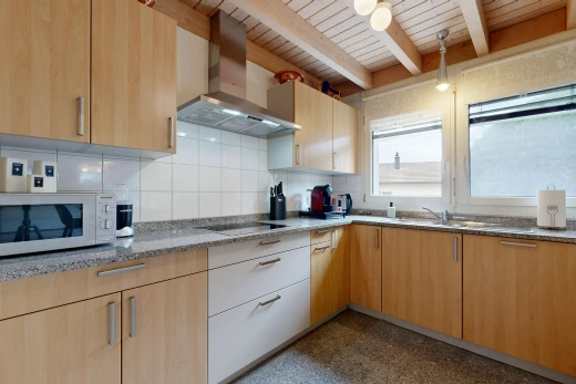 cuisine avec hotte, light brown cabinets, armoires marron clair, micro-ondes, et backsplash
