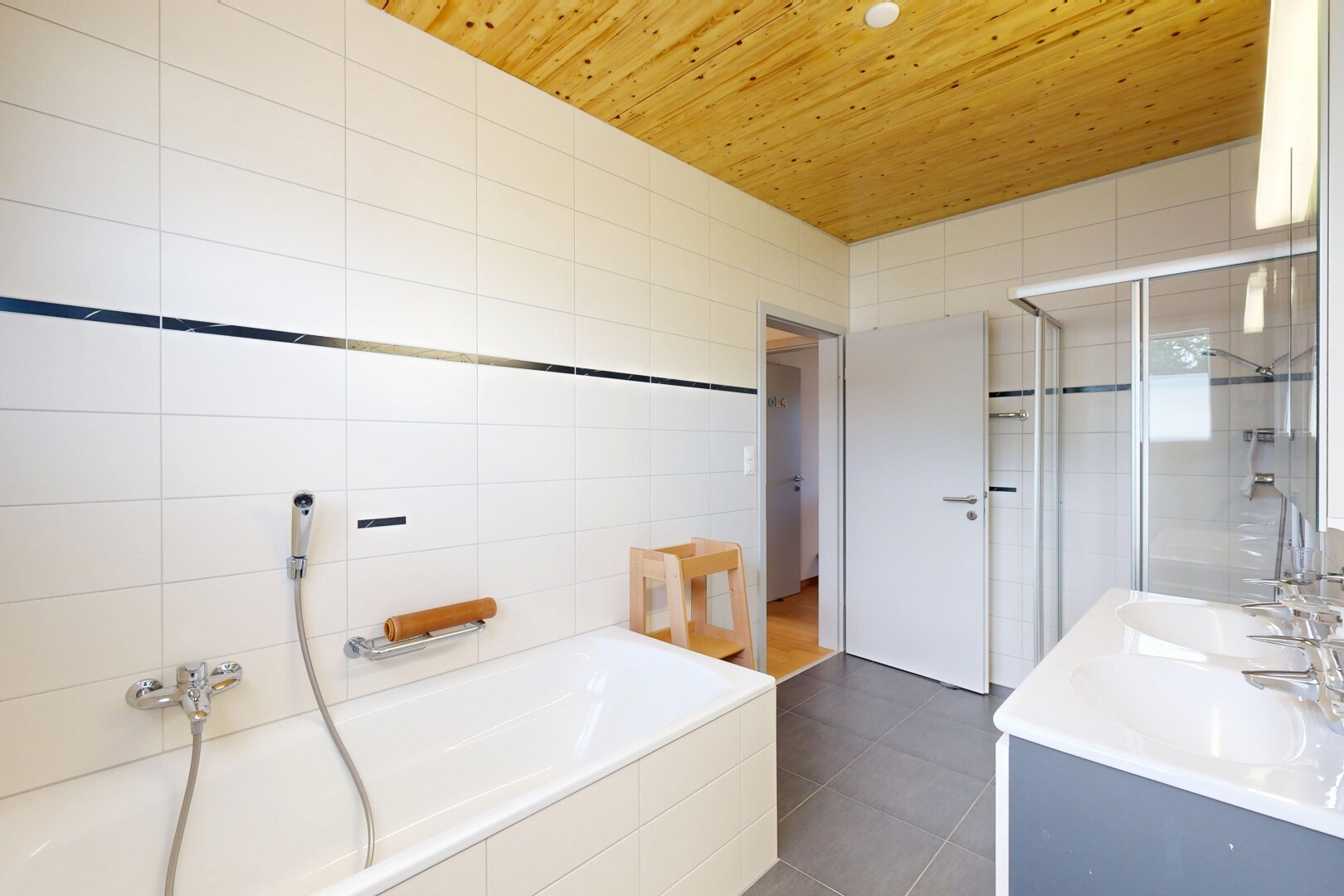 salle de bains avec bain, tile wall, mur en carrelage, wood ceiling, et plafond en bois