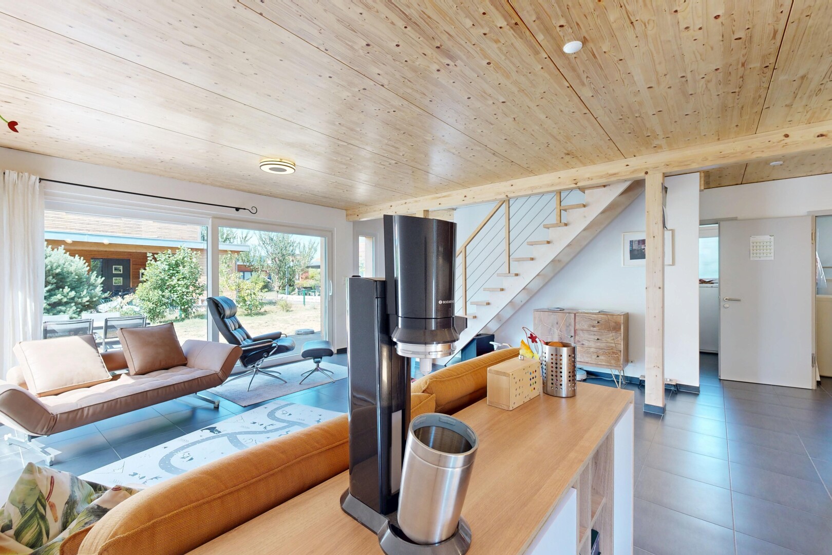 salon avec escaliers, wood ceiling, plafond en bois, éclairage encastré, et drywall