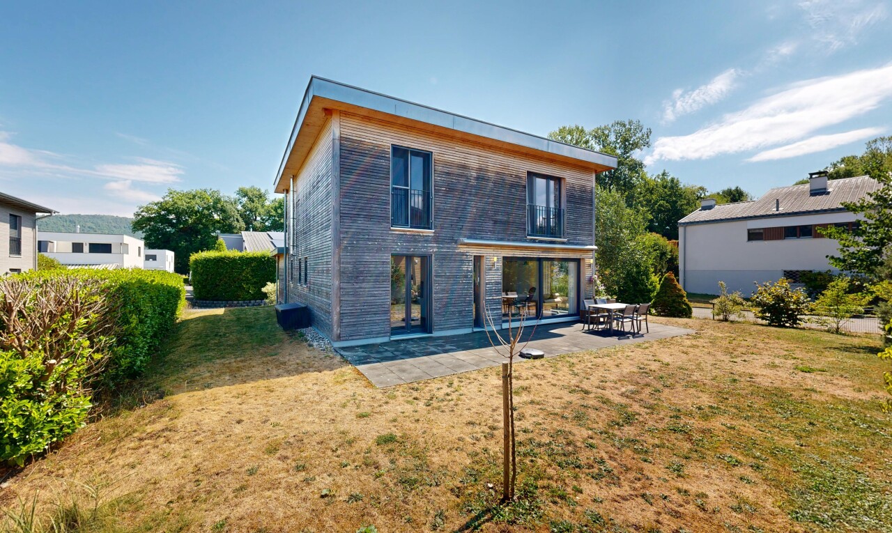 façade avec bardage horizontal, pelouse, terrasse, property visible, et day time