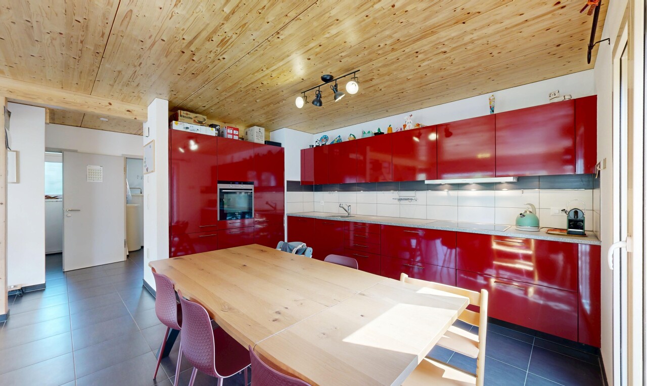 cuisine avec éclairage sur rail, wood ceiling, plafond en bois, armoires rouges, et red cabinets