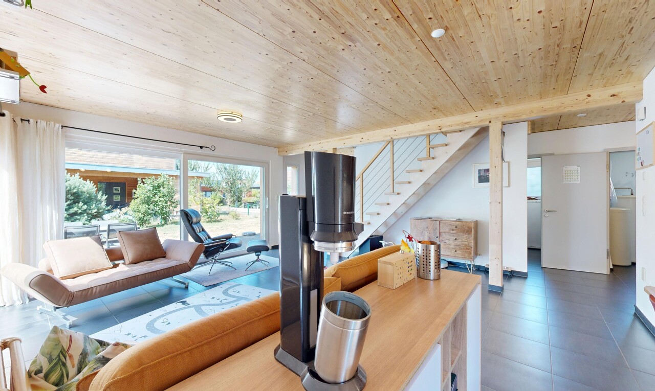 salon avec escaliers, wood ceiling, plafond en bois, éclairage encastré, et drywall