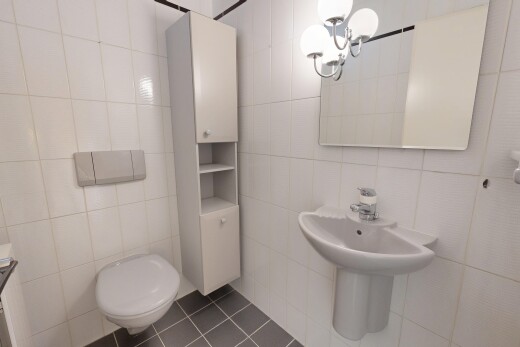 half bath with tile walls and dark tile patterned flooring
