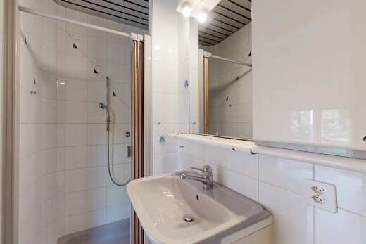 bathroom with tile walls, a shower stall, decorative backsplash, and vanity
