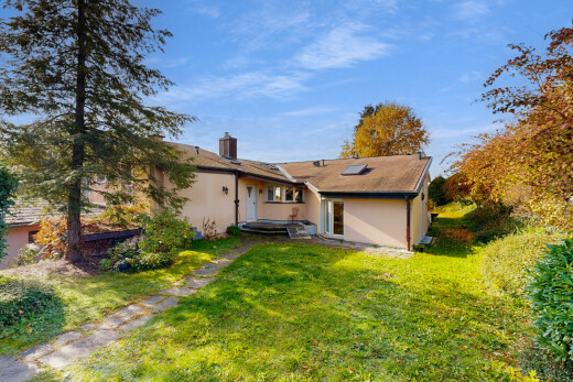 outdoor house featuring a yard, a chimney, and stucco siding