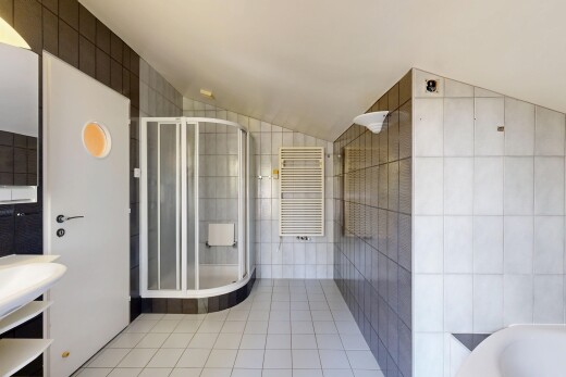bathroom featuring tile walls, a towel warming rack, radiator, light tile patterned flooring, and a stall shower