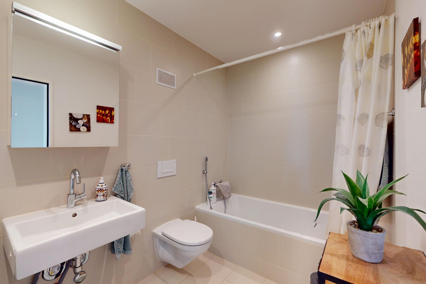 salle de bains avec tile wall, mur en carrelage, douche-bain combinés, toilette, et miroir