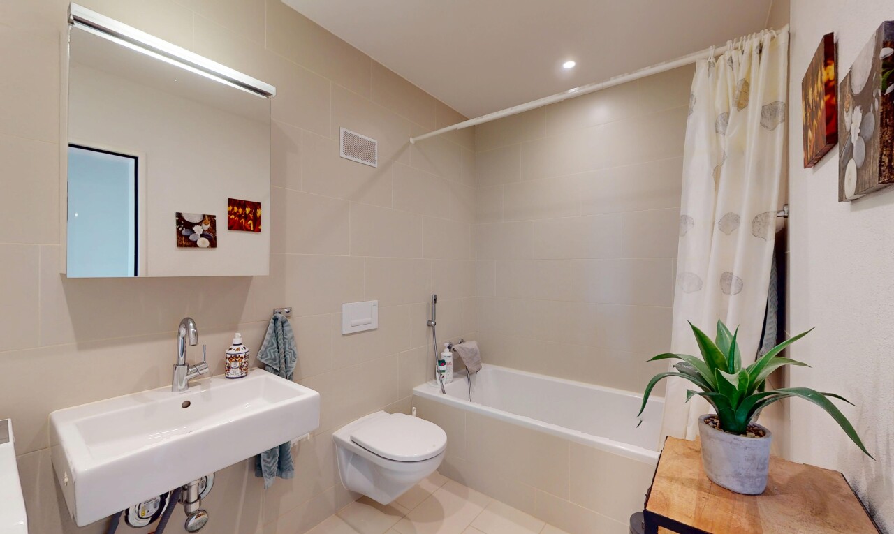 salle de bains avec tile wall, mur en carrelage, douche-bain combinés, toilette, et miroir