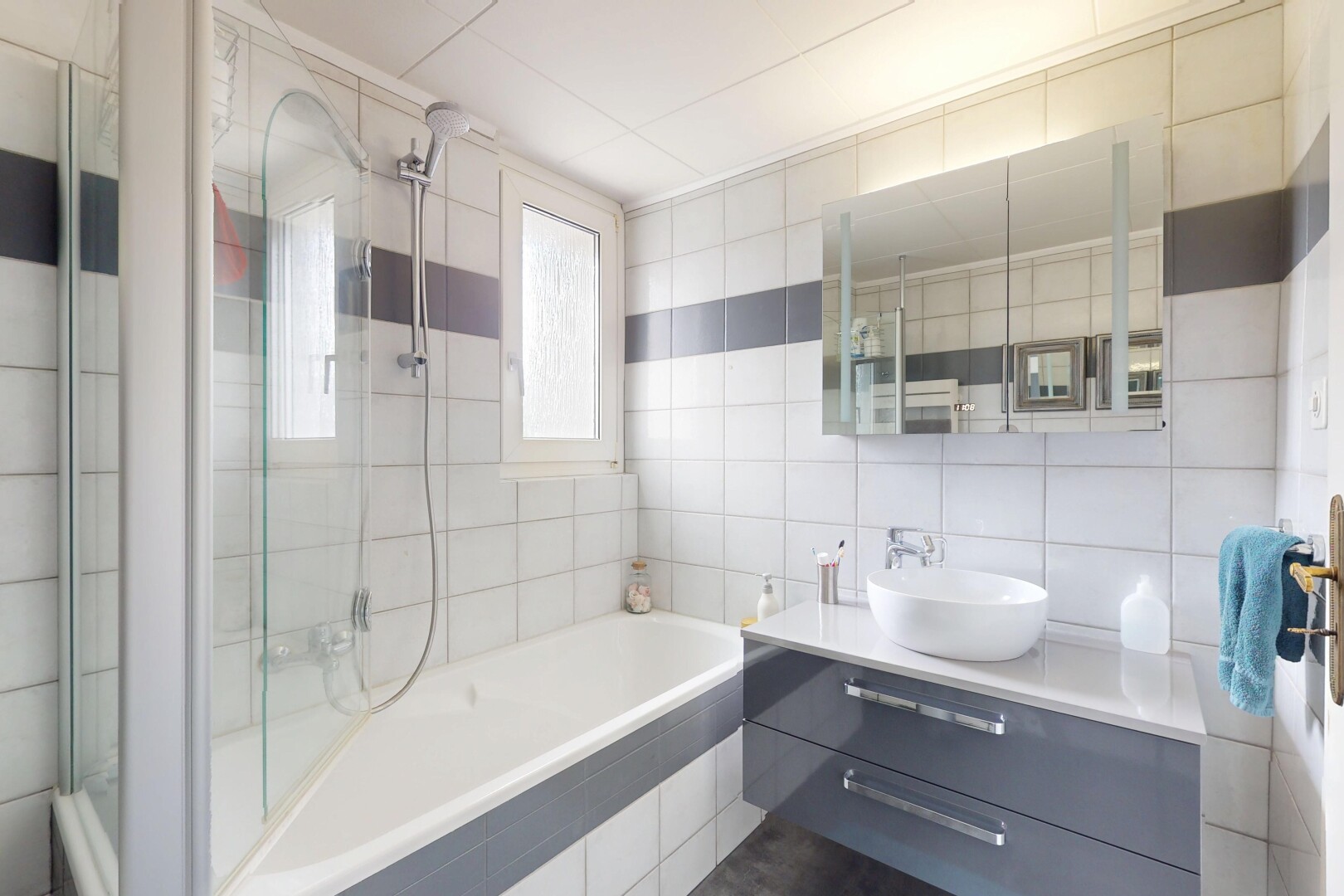 salle de bains avec tile wall, mur en carrelage, natural light, lumière naturelle, et tile tub