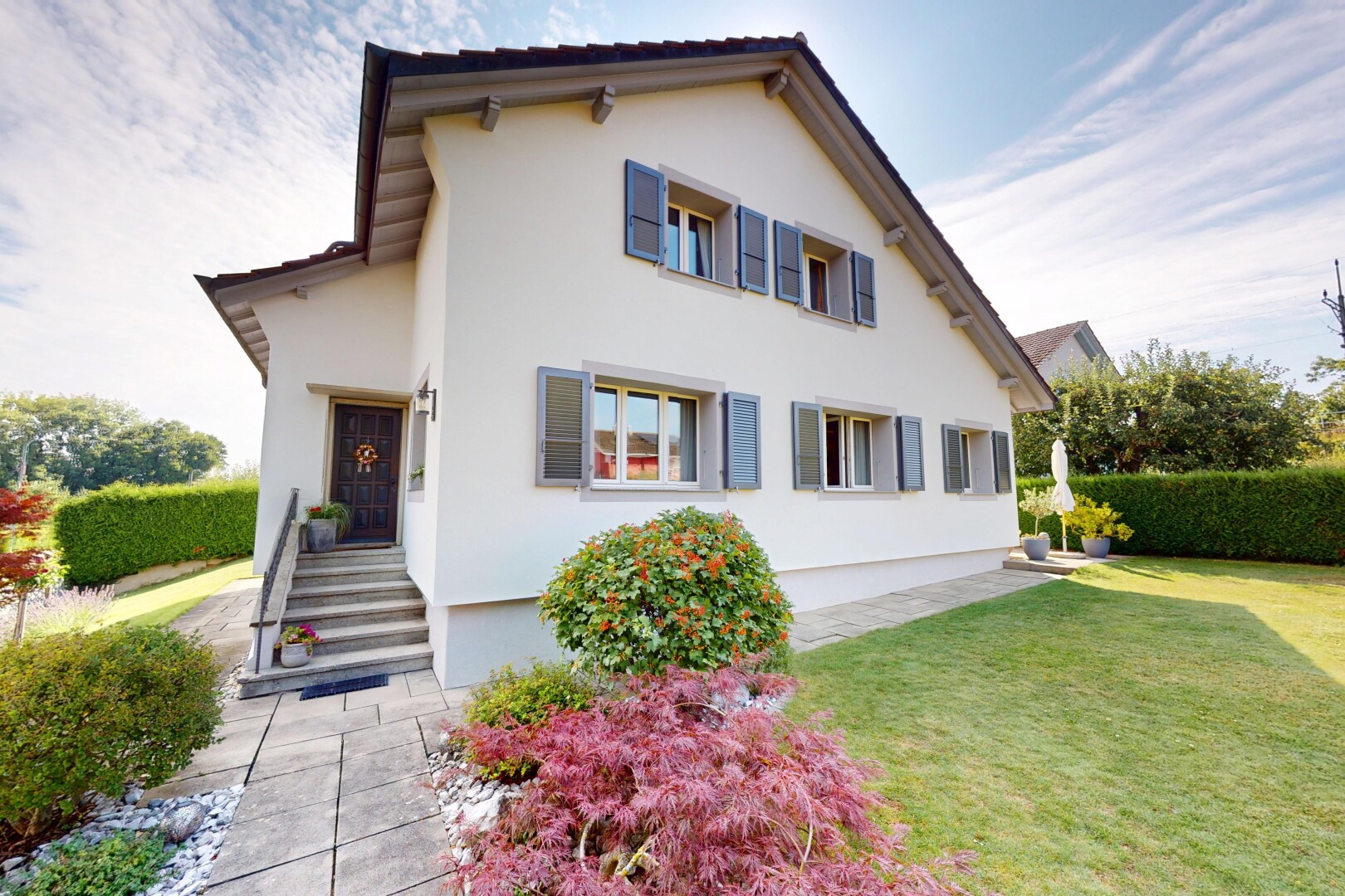 façade avec perron, property visible, pelouse, bardage en stuc, et day time